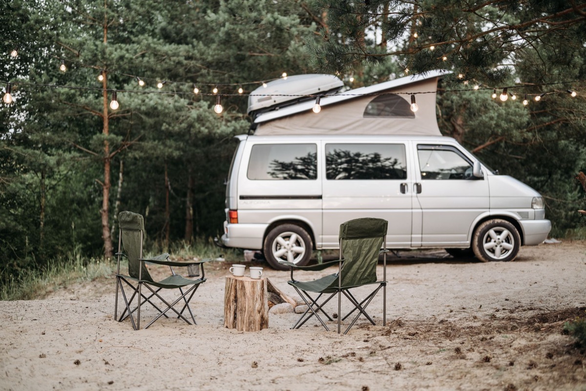 camper van with camping gear and dirt tire